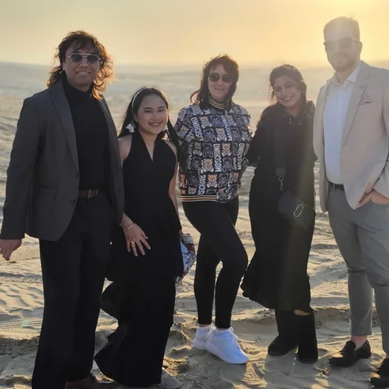 Five teammates in the desert at sunset on the Doha offsite