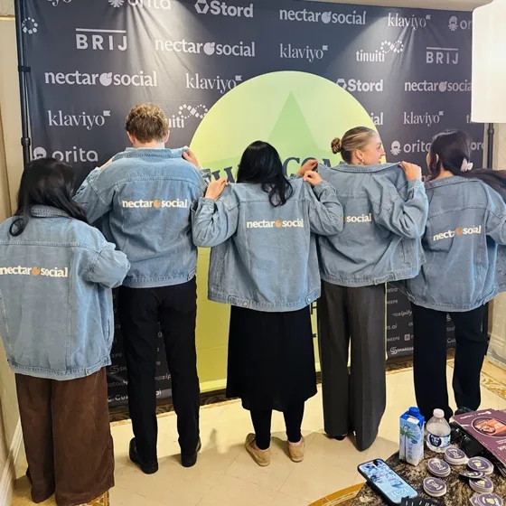 Five teammates showing the backs of their Nectar denim jackets