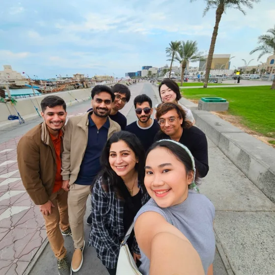 Seven teammates in a selfie on the Doha waterfront