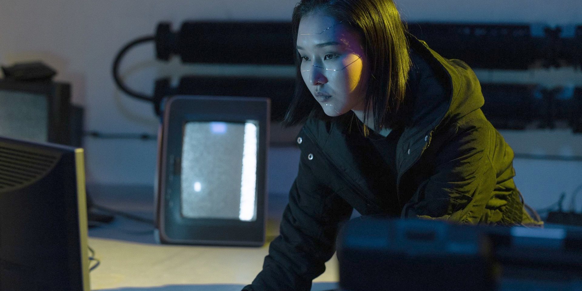 A developer in a dark room, her face lit by the screen.
